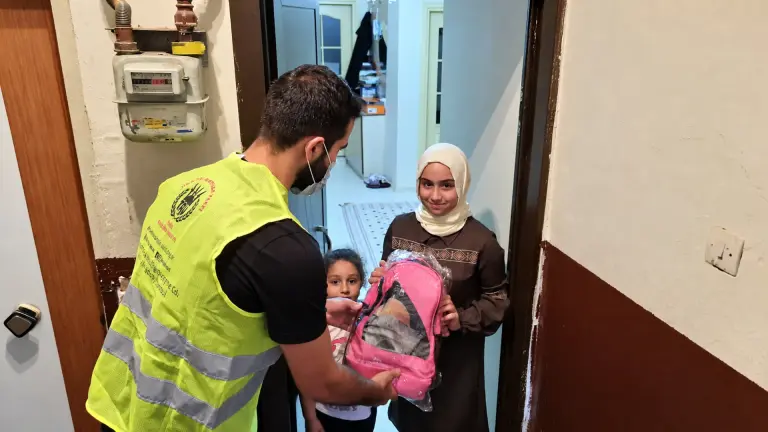 Gönüllü kardeşlik paketini bir aileye teslim ediyor