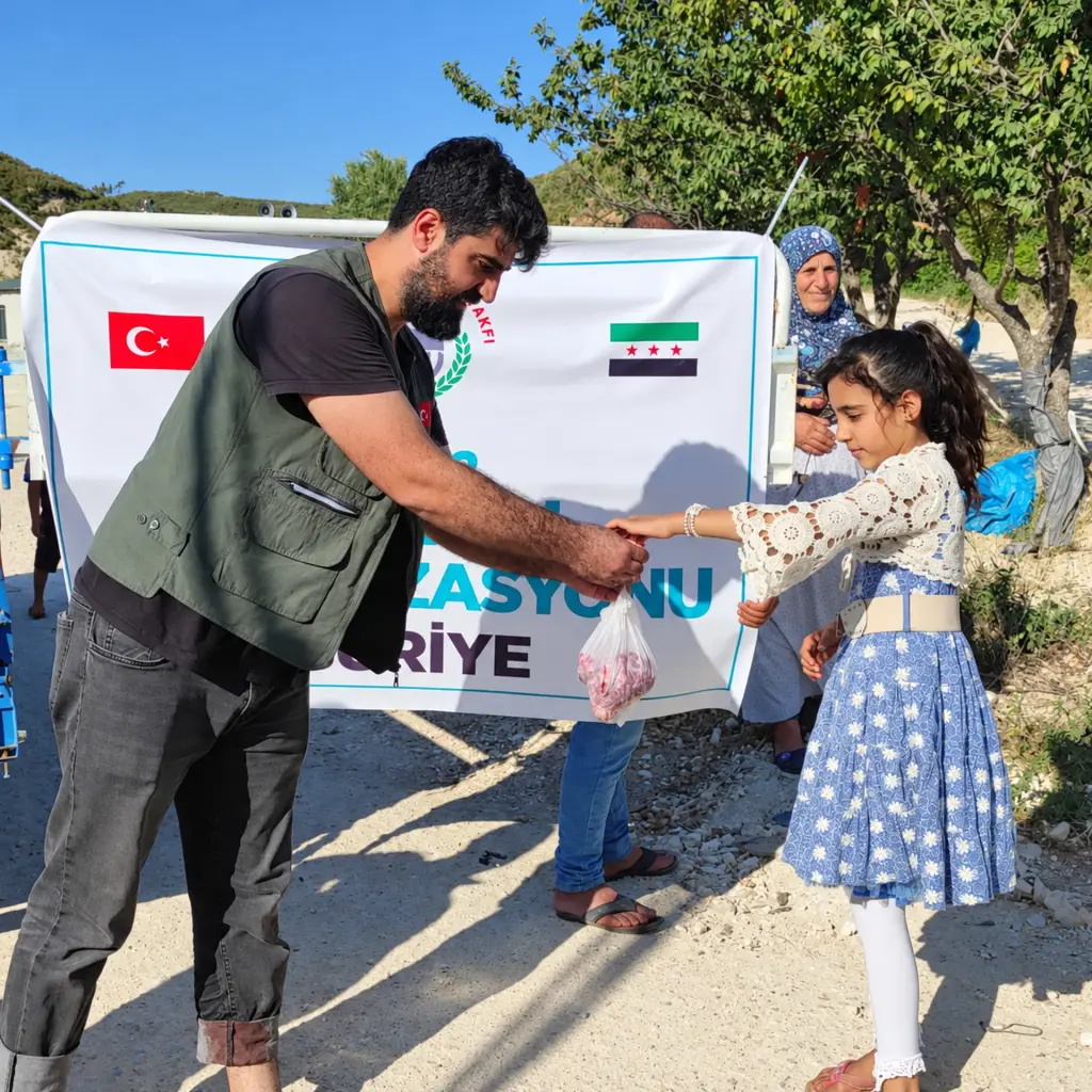 Gönüllü bir kız çocuğuna paket teslim ediyor