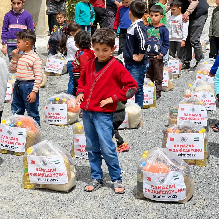 Ramazan gıda paketlerinin arasında bir çocuk